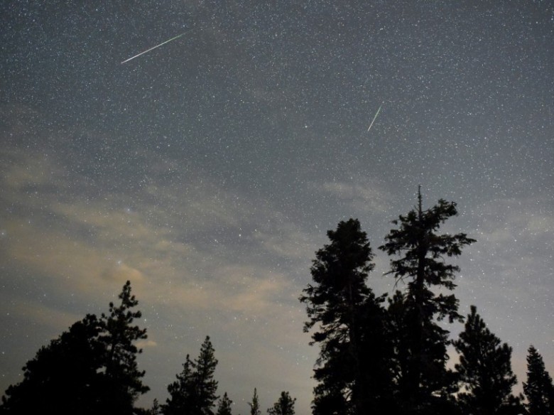 SPRING MOUNTAINS NATIONAL RECREATION AREA, NV - AUGUST 13: A pair of Perseid meteors streak across the sky above desert pine trees on August 13, 2015 in the Spring Mountains National Recreation Area, Nevada. The annual display, known as the Perseid shower because the meteors appear to radiate from the constellation Perseus in the northeastern sky, is a result of Earth's orbit passing through debris from the comet Swift-Tuttle.   Ethan Miller/Getty Images/AFP