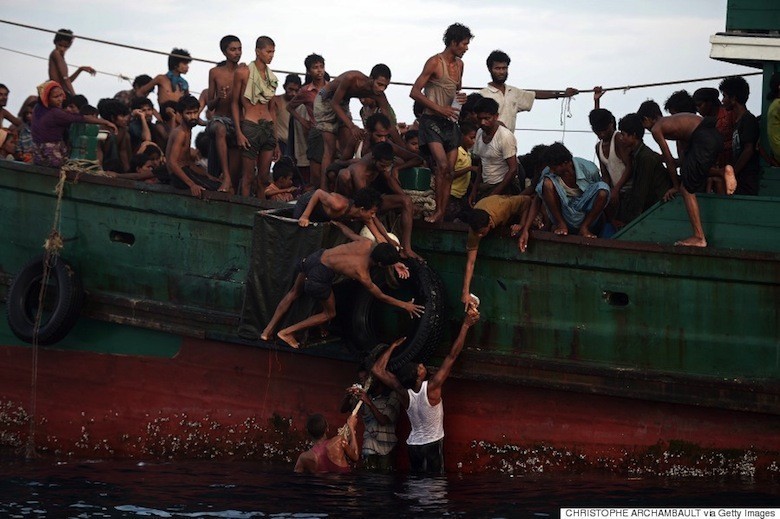 Rohingya migrants pass food supplies dropped by a Thai army helicopter to others aboard a boat drifting in Thai waters off the southern island of Koh Lipe in the Andaman sea on May 14, 2015. A boat crammed with scores of Rohingya migrants -- including many young children -- was found drifting in Thai waters on May 14, with passengers saying several people had died over the last few days. AFP PHOTO / Christophe ARCHAMBAULT (Photo credit should read CHRISTOPHE ARCHAMBAULT/AFP/Getty Images)