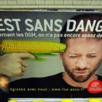 des-gens-passent-devant-l-affiche-d-une-campagne-contre-les-ogm-menee-par-l-association-france-nature-environnement-le-15-fevrier-2011-dans-le-metro-parisien_5327181